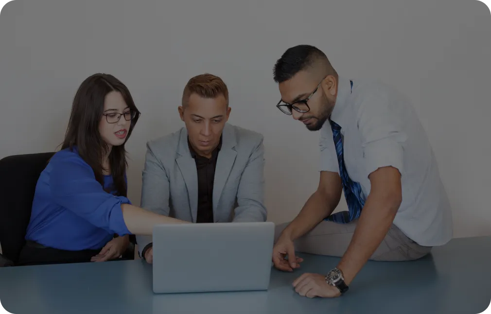 tres personas trabajando en una laptop